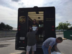 UPS volunteers filling their truck with boxes of books and supplies.